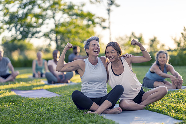 Women on yoga mat posing with flexed arms